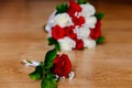 The groom`s boutonniere of red roses and the bride`s bouquet of red and white roses Royalty Free Stock Photo