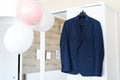 Groom`s dark blue costume. Groom`s morning. Festive atmosphere in a bright white room and balloon decoration Royalty Free Stock Photo