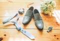 Groom`s grey shoes, blue tie and watch on the wooden background. Wedding details photo. Bouquet, rings and perfumes accessories Royalty Free Stock Photo