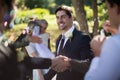 Groom shaking hand with guest in park Royalty Free Stock Photo