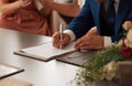 Groom signing marriage certificate