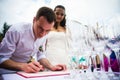 Groom signs documents on registration of marriage. A young couple signs the wedding documents. Outdoor wedding ceremony