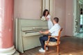 The groom sits at the piano and plays the bride Royalty Free Stock Photo