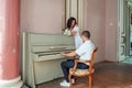 The groom sits at the piano and plays the bride a melody Royalty Free Stock Photo