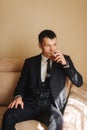 Groom sits on sofa and drind a wiskey Royalty Free Stock Photo