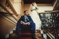 Groom is sitting on the stairs on the background smiling bride Royalty Free Stock Photo