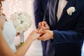 Groom puts on a wedding ring on the finger of a beautiful bride Royalty Free Stock Photo