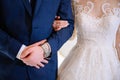 The groom in a suit hugs the bride in a wedding dress