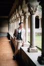 Groom in a suit stands on a pillared loggia in an old building on Lake Como