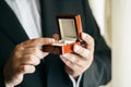 Groom in suit and tie holding wedding rings