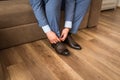 Groom wearing shoes on wedding day, tying the laces and preparing. Business man dressing up with elegant shoes.