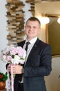 Groom at wedding tuxedo smiling and waiting for bride in the hall of the hotel . Rich groom at wedding day. Elegant groom in costu Royalty Free Stock Photo