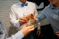 Groom with white shirt and bow tie with friends drinking whiskey Royalty Free Stock Photo