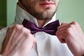 The groom in a white shirt fixing his bow tie Royalty Free Stock Photo