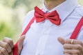 The groom in a shirt with a red bow tie and in suspenders Royalty Free Stock Photo