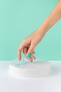 Groomed womans hand with podium on turquoise background Royalty Free Stock Photo