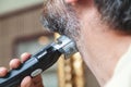 Grooming beard with gray hair trimmer closeup Royalty Free Stock Photo