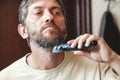 Grooming beard with gray hair trimmer closeup Royalty Free Stock Photo