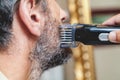 Grooming beard with gray hair trimmer closeup Royalty Free Stock Photo