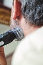 Grooming beard with gray hair trimmer closeup Royalty Free Stock Photo