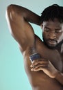 Grooming, hygiene and black man with armpit deodorant on a blue background in studio. Skincare, cleaning and