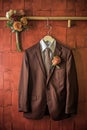 grooms suit, tie, and boutonniere hanging neatly