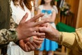 Grooms wear their wedding rings on their fingers. Groom in military uniform. The priest puts on a wedding ring.