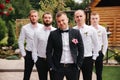 Stylish groomsman with groom standing on the backyard and prepare for the wedding ceremony. Friend spend time together