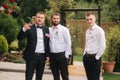 Stylish groomsman with groom standing on the backyard and prepare for the wedding ceremony. Friend spend time together