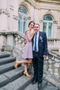 Groomsman posing with cute bridesmaid on the stairs of classical austrian building