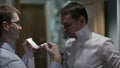 Groomsman tying groom's tie.