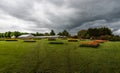 Groot-Bijgaarden, Flanders Belgium : Upcoming dark clouds over the gardens, green meadows and glasshouses at the Royalty Free Stock Photo