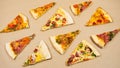 Grop of triangular slices of different types of pizza on a beige kraft paper background
