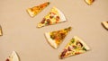 Grop of triangular slices of different types of pizza on a beige kraft paper background