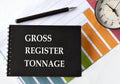 GROSS REGISTER TONNAGE - words on a black notebook with a chart and alarm clock in the background Royalty Free Stock Photo