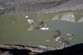 The peak of Grossglockner mountain is reflected in the water collected from the melting Pasterze glacier. Royalty Free Stock Photo