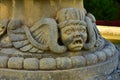 Grotesque face sculpture made in limestone, as part of the decorations at the base of a fountain