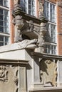 Grotesque gargoyle on front of colorful tenement house, Gdansk, Poland