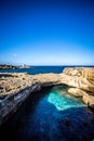 The Grotta della Poesia in the Puglia region of southern Italy with clear waters and a crystal clear sky