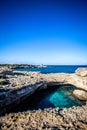 The Grotta della Poesia in the Puglia region of southern Italy with crystal clear blue water and blue sky