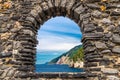 Grotta di Lord Byron with blue water and coast with rock cliff through stone wall window, Portovenere town, Ligurian sea, Riviera