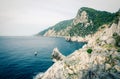 Grotta di Lord Byron with blue water, coast with rock cliff, yellow boat and blue sky near Portovenere town, Ligurian sea, Riviera