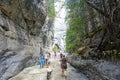 Families hiking the Grotto Canyon trail with rock climbers climbing the walls in the background, outside Canmore, Alberta, Canada.
