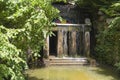 Grotto with a statue of Venus and an artificial waterfall. An ancient fountain with running water, a female sculpture and a forest Royalty Free Stock Photo