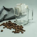 Ground, a bag for coffee drops and a transparent mug on the table. Drop coffee on a gray background with coffee beans. coffee Royalty Free Stock Photo