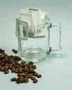 Ground, a bag for coffee drops and a transparent mug on the table. Drop coffee on a gray background with coffee beans. coffee i Royalty Free Stock Photo