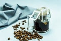 Ground, a bag for coffee drops and a transparent mug on the table. Drop coffee on a gray background with coffee beans. coffee i Royalty Free Stock Photo