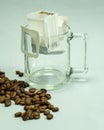 Ground, a bag for coffee drops and a transparent mug on the table. Drop coffee on a gray background with coffee beans. coffee Royalty Free Stock Photo