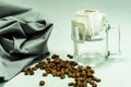 Ground, a bag for coffee drops and a transparent mug on the table. Drop coffee on a gray background with coffee beans. coffee Royalty Free Stock Photo