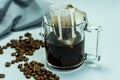 Ground, a bag for coffee drops and a transparent mug on the table. Drop coffee on a gray background with coffee beans. coffee Royalty Free Stock Photo